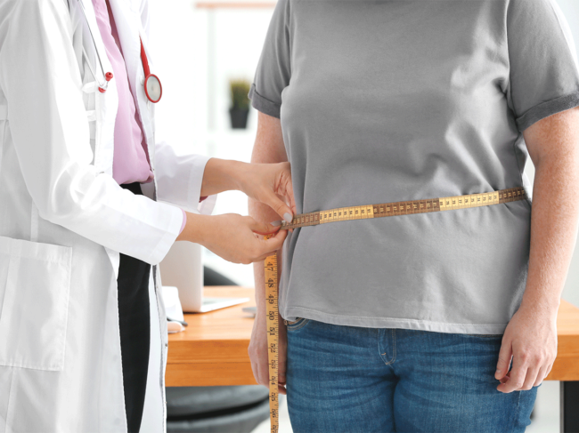 Doctor measuring patient's waist